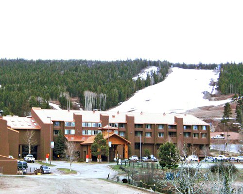 Exterior view of the Angel Fire Cabin Share Phase I resort covered in snow.