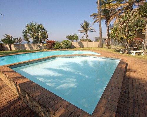 An outdoor swimming pool with kiddie pool.