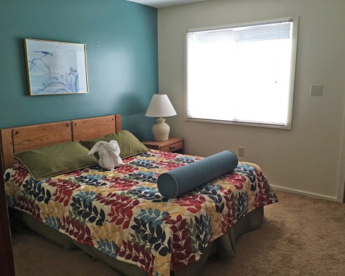 A WELL FURNISHED BEDROOM WITH AN OUTSIDE VIEW.