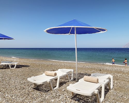 A view of chaise lounge chairs on the beach facing the sea.