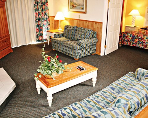 A well furnished living room and bedroom with king bed.