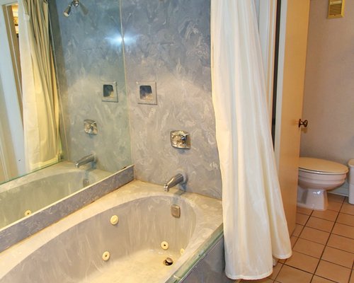 A bathroom with shower and bathtub.