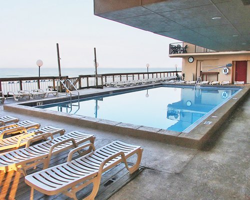 An outdoor swimming pool with chaise lounge chairs.