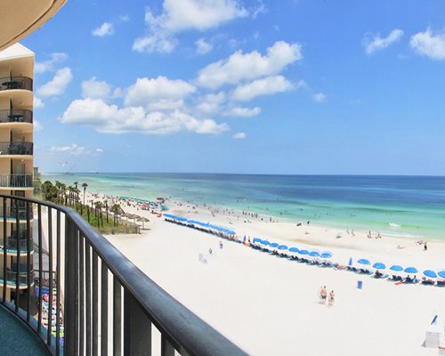A beach with chaise lounge chairs and sunshades from the balcony.