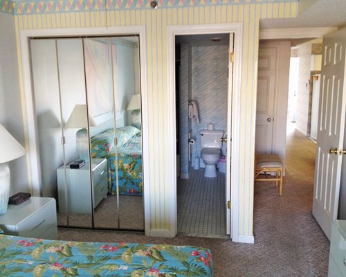 A well furnished bedroom with king bed and view of bathroom.