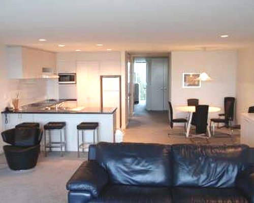 An open plan living dining and kitchen area with breakfast bar.