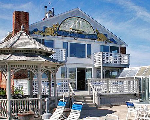 Exterior view of a unit at The Ocean Club on Smuggler's Beach alongside chaise lounge chairs.