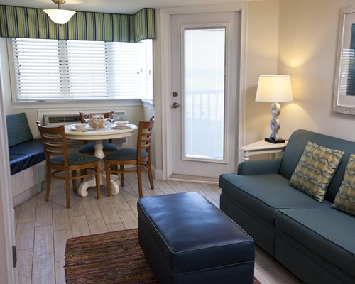 A well furnished living room with dining area and balcony.