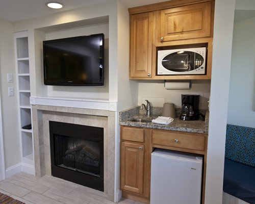 An open plan living room and kitchen with television and fireplace.