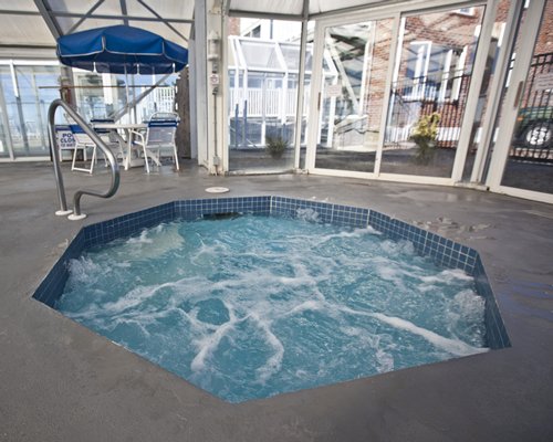 An indoor hot tub with sunshades and patio furniture.
