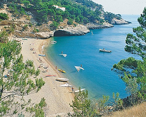 An aerial view of the beach with boats alongside the ocean.
