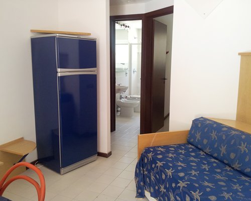 A furnished living room with a refrigerator.