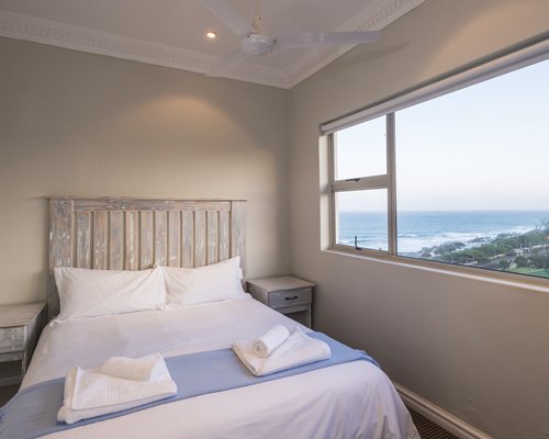 A well furnished bedroom with ocean view.