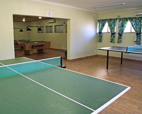 An indoor recreation room with ping pong and pool table.