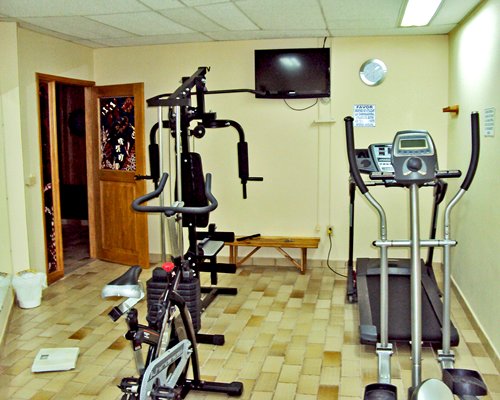 A well equipped fitness center with a television.