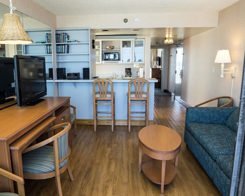 An open plan living room with a television and kitchen.
