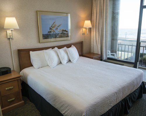 A well furnished bedroom with a queen size bed and ocean view.