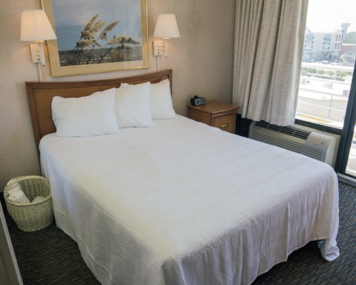 A well furnished bedroom with a queen bed and an outside view.