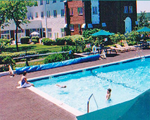 Outdoor swimming pool with chaise lounge chairs and sunshades.