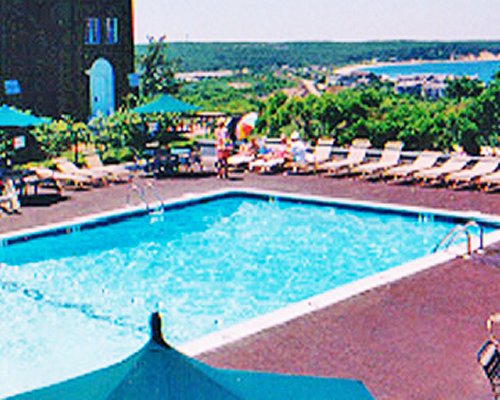 An outdoor swimming pool with chaise lounge chairs and sunshade.
