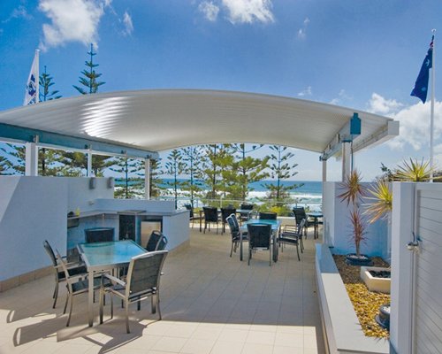 An outdoor glass top dining area alongside the ocean.