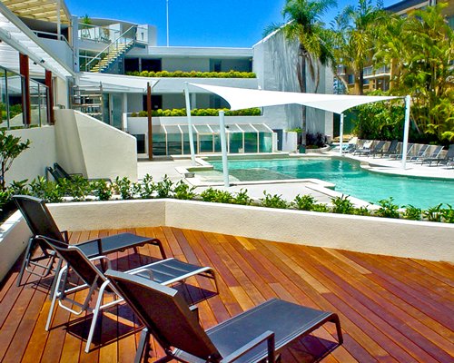 An outdoor swimming pool with chaise lounge chairs alongside the resort unit.