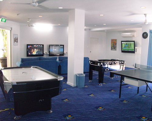 An indoor recreational room with soccer pool and ping pong table.