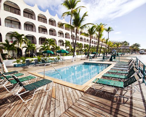 An outdoor swimming pool with chaise lounge chairs.