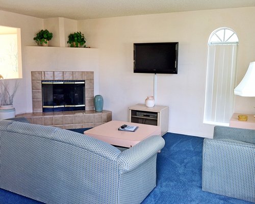 A well furnished living room with television and fireplace.