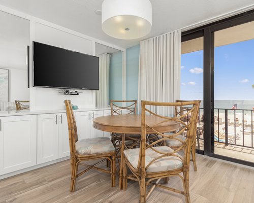 Living room with open plan kitchen dining area breakfast bar and television.