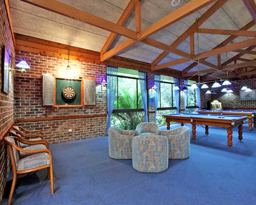 An indoor recreation room with pool tables and an outside view.