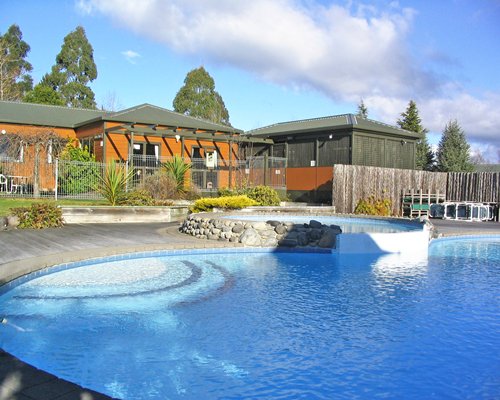 Exterior view of Kaimanawa Lodge with large outdoor swimming pool and landscaping.