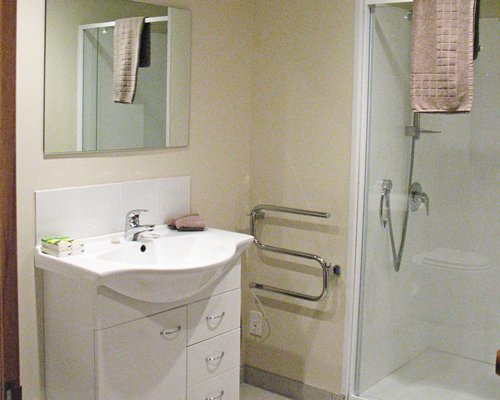 A bathroom with shower stall and sink.