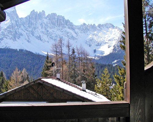 Balcony view of the snowy mountain and wooded area.
