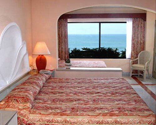 A well furnished bedroom with an ocean view.