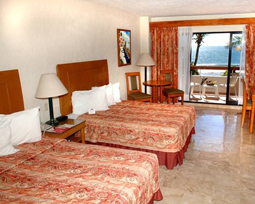 A well furnished bedroom with two king size bed and an outside view.