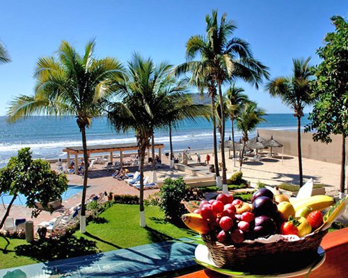 An outdoor swimming pool with chaise lounge chairs alongside the beach.