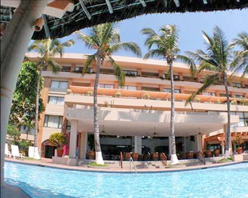 An outdoor swimming pool alongside multi story resort units.