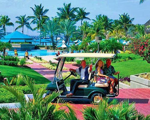 View of people on a golf cart at landscaped pathway.