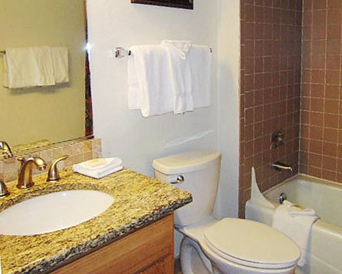 A bathroom with a bathtub and a single sink vanity.