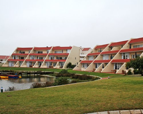 A scenic exterior view of multi story units alongside the waterfront.