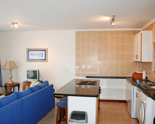 An open plan living room and kitchen area with a breakfast bar.