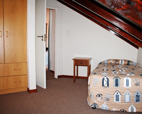 A well furnished bedroom with twin bed and stairway.