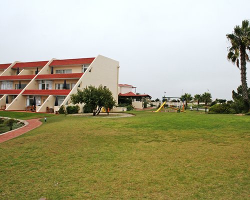 Scenic exterior view of multi story resort units alongside playscape area.