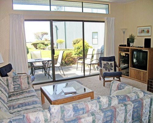A well furnished living room with a double pull out sofa television and patio.