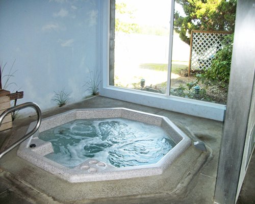 An indoor hot tub with an outside view.
