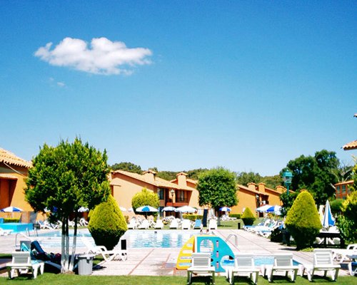An exterior view of resort units alongside a swimming pool.