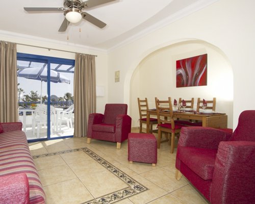 A well furnished living room with a dining area and outdoor view.