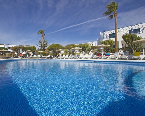 An outdoor swimming pool with chaise lounge chairs.