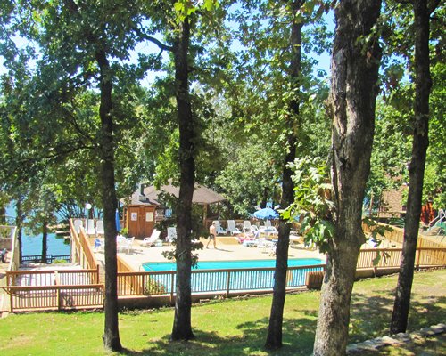 An outdoor swimming pool from a wooded area.